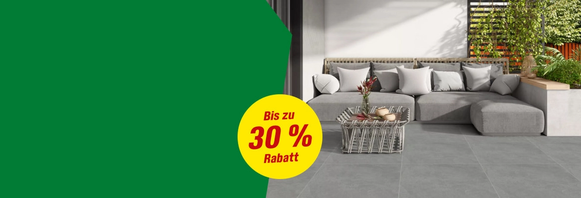 Graue Lounge-Ecke auf einer Terrasse mit Pflanzen.